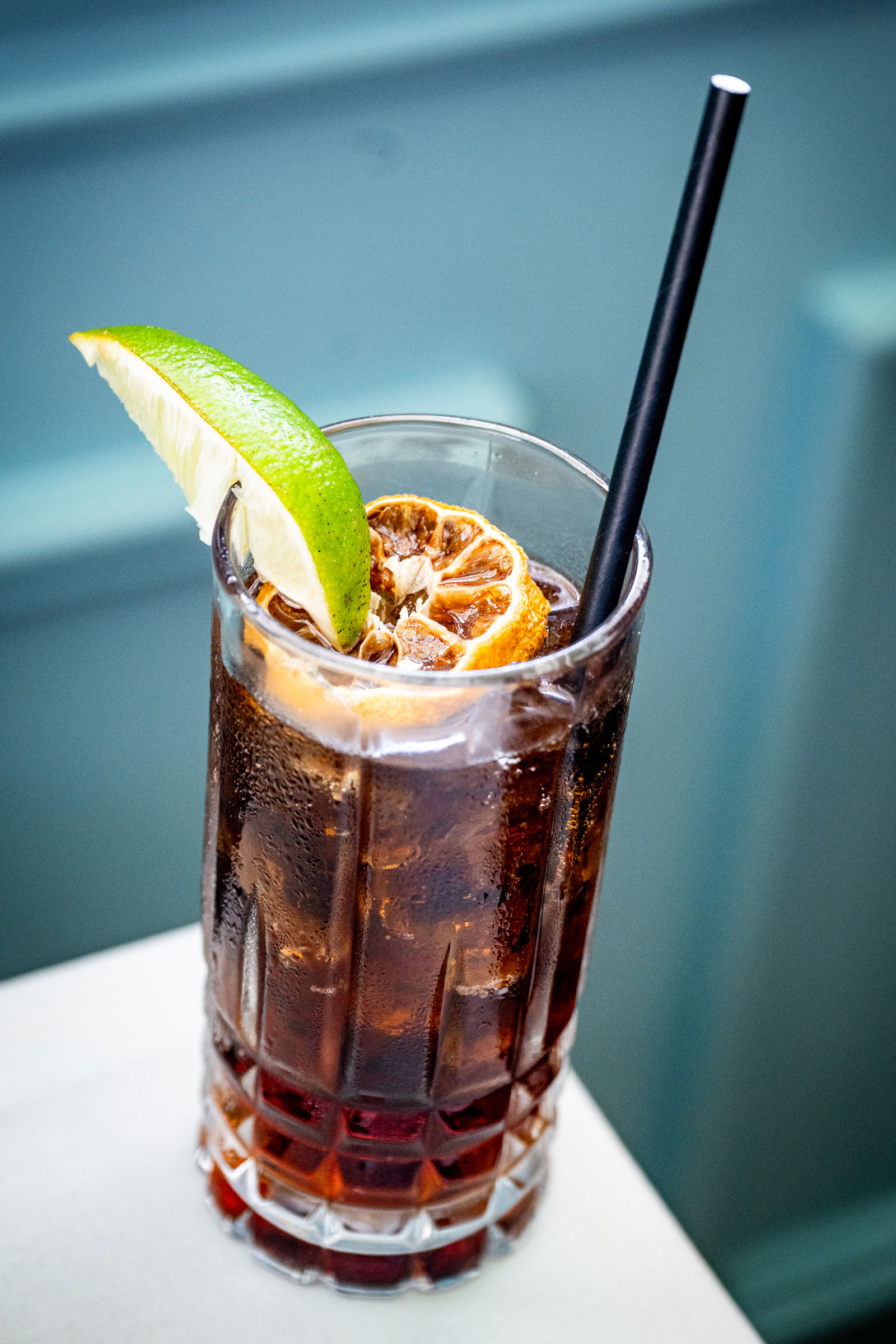 Sophisticated deep red cocktail garnished with a botanical leaf