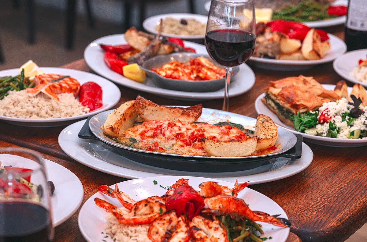 Various Greek Dishes on a Table: Shrimp, Salmon, Fish