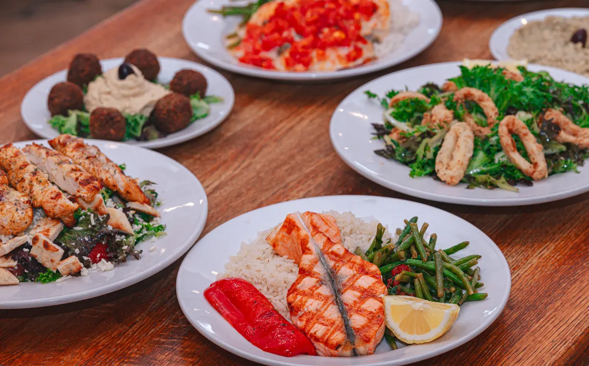 Table spread of dishes: Salmon, chicken Salad, Falafel, Calamari